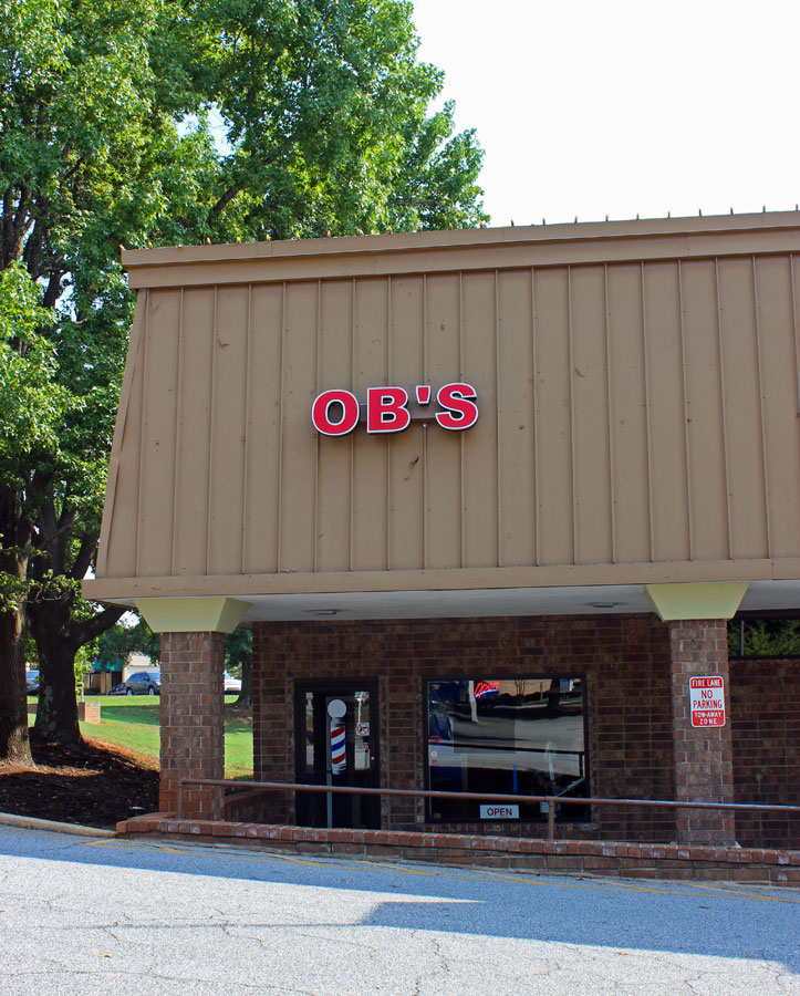 The OB'S storefront with its red sign and barber pole by the door